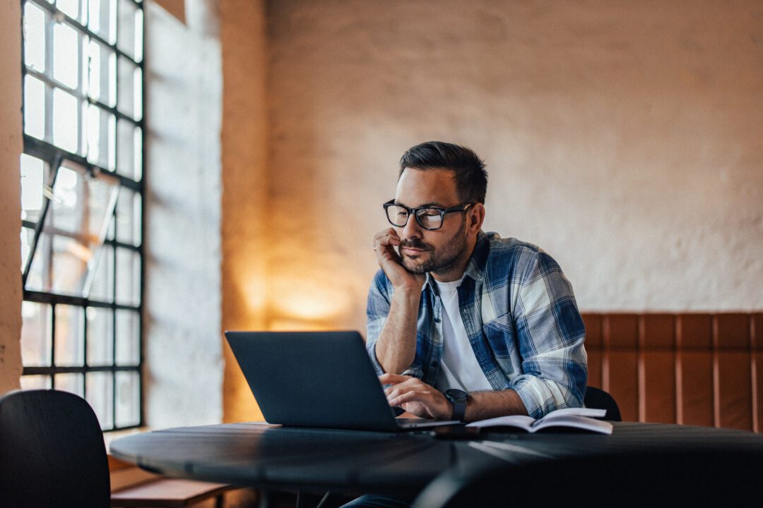 Thoughtful businessman working over the laptop, searching someth
