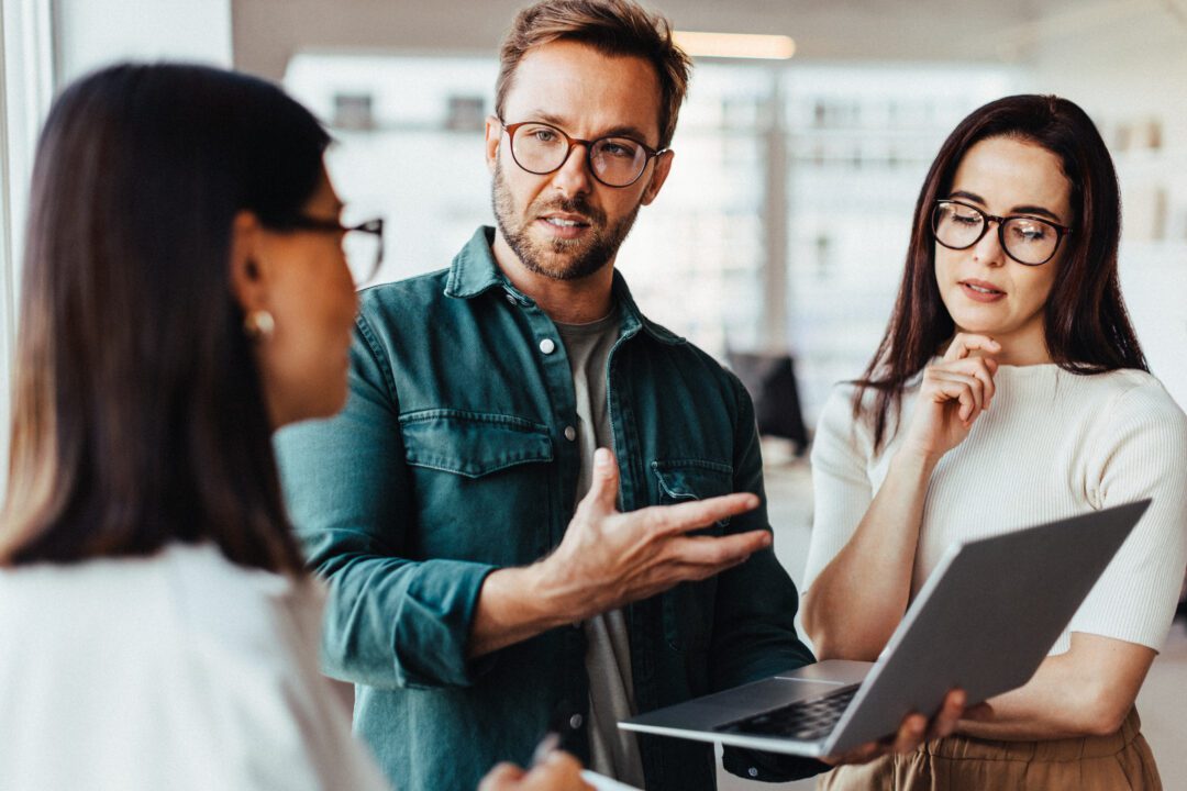 Business people having a discussion and using a laptop